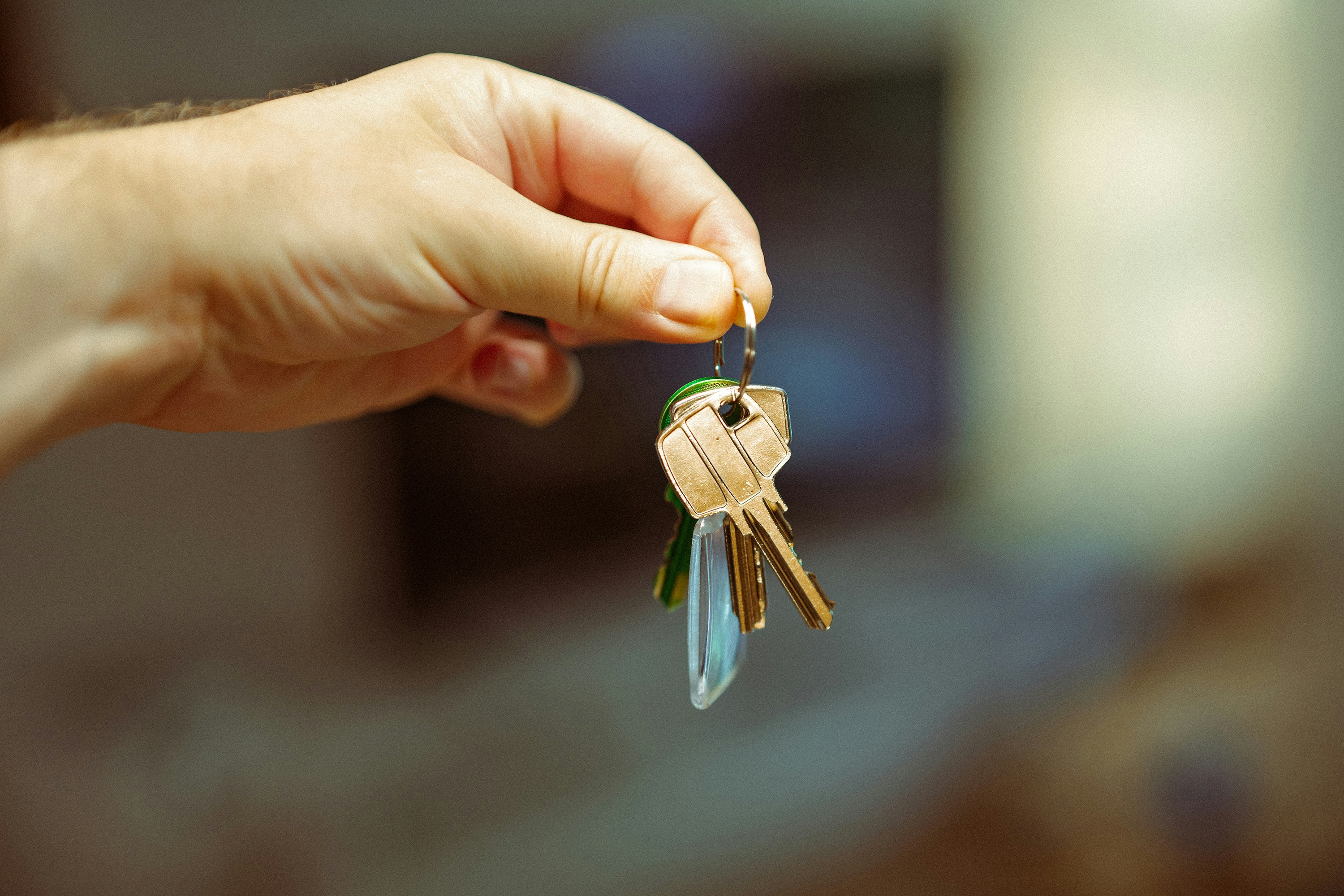 person's hand dangling a ring of house keys
