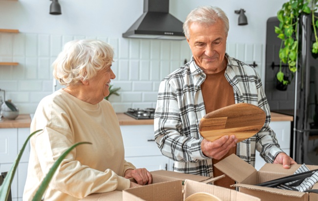 Elderly Couple Smiling while Packing